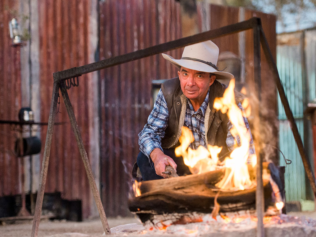 Outback Pioneers photograph of Scotty stoking the campfire